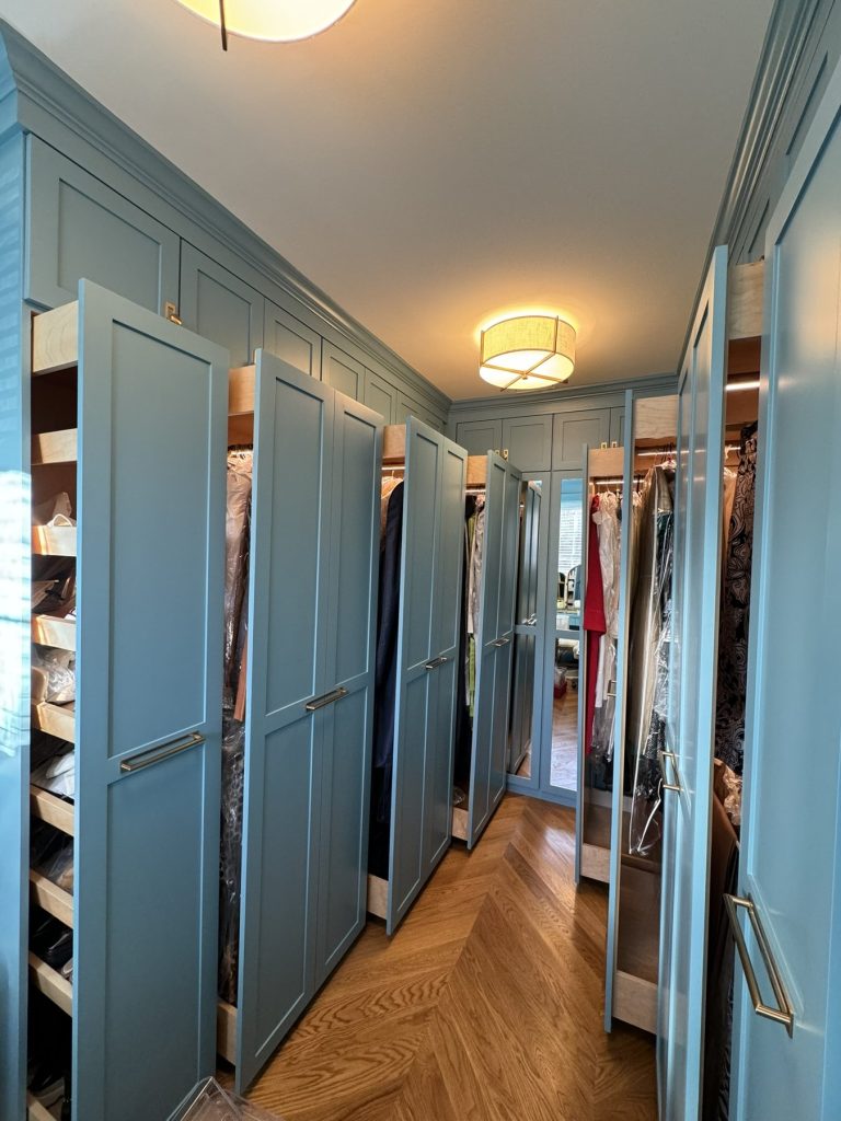 Custom walk-in closet with open pull-out storage and mirrored dressing area