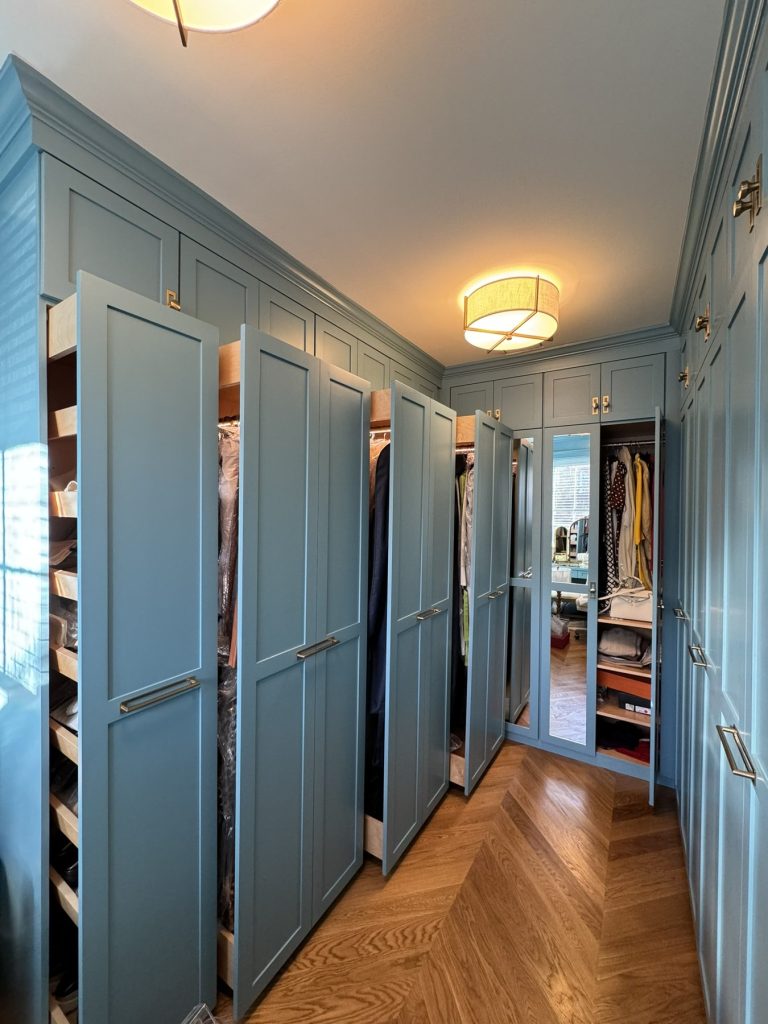 Pull-out shoe racks in custom sage blue walk-in closet built by SMFW
