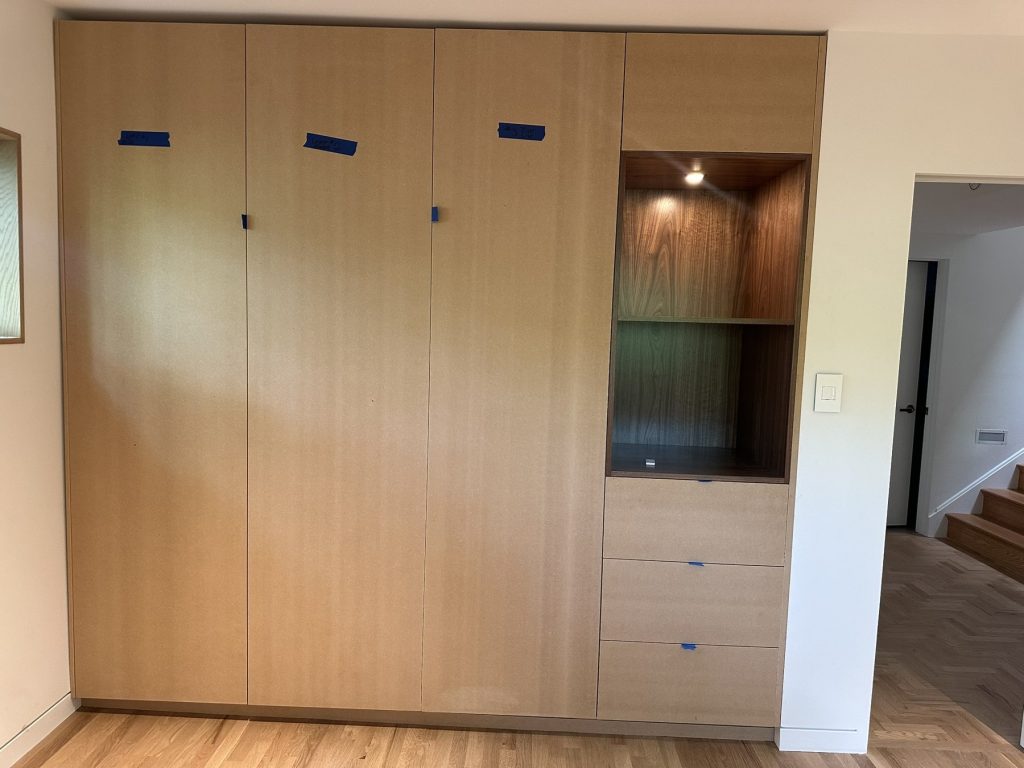 Built-in maple wardrobe wall closed, with open display niche and drawers