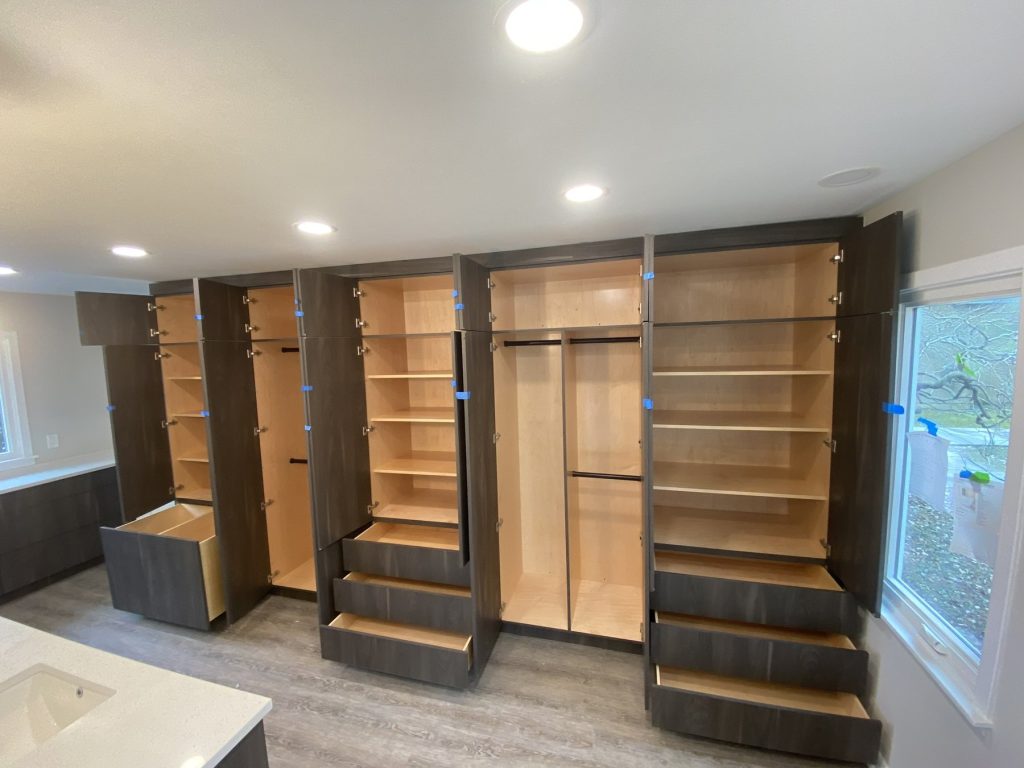 Gray wardrobe cabinets open showing adjustable fitted interiors