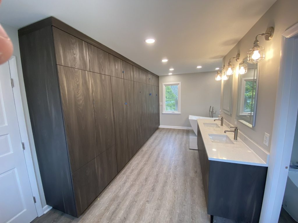 Hallway run of gray wardrobe closets alongside double vanity