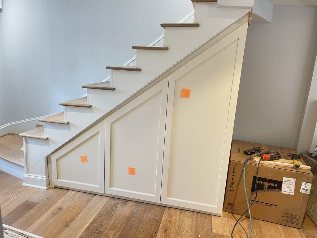 Under-stair storage closets with paneled doors built by SMFW