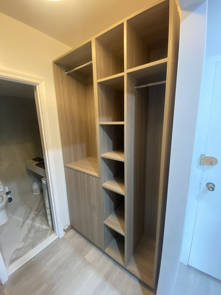 White oak walk-in closet organizer with shelving and hanging sections