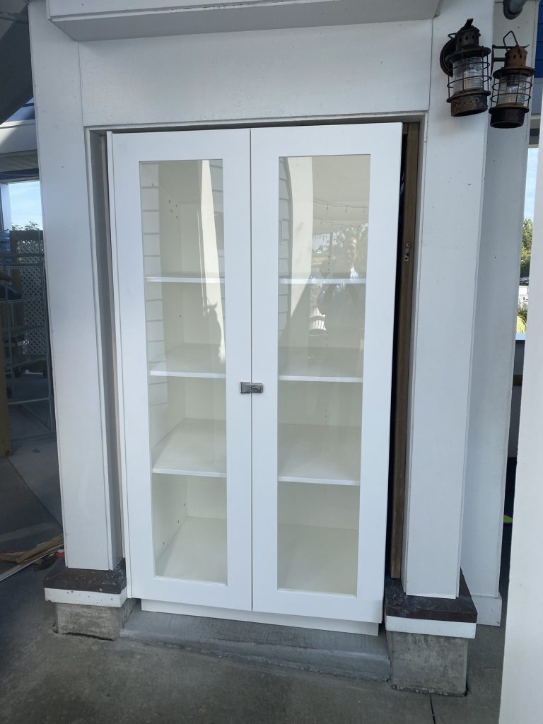 Weather-rated white HDPE display cabinet with glass doors built by SMFW for a coastal restaurant