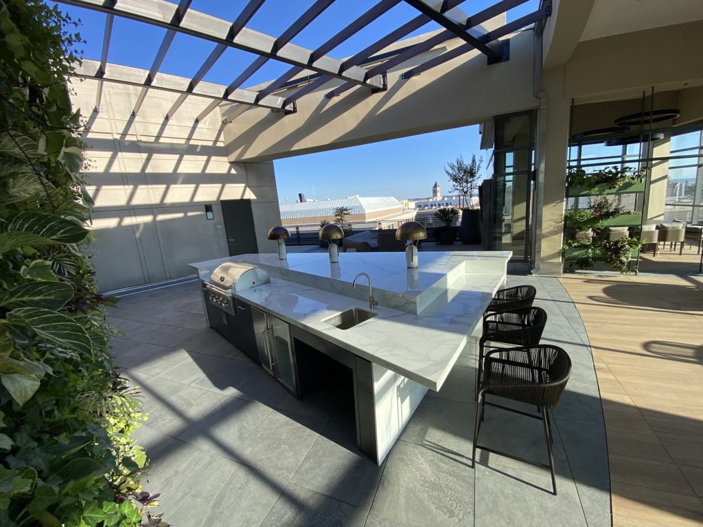 Outdoor kitchen island with bar stools and living green wall on a DC rooftop