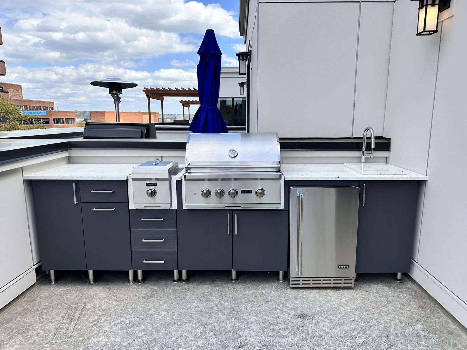 Rooftop terrace outdoor kitchen with weather-rated cabinetry, grill, and refrigeration by SMFW
