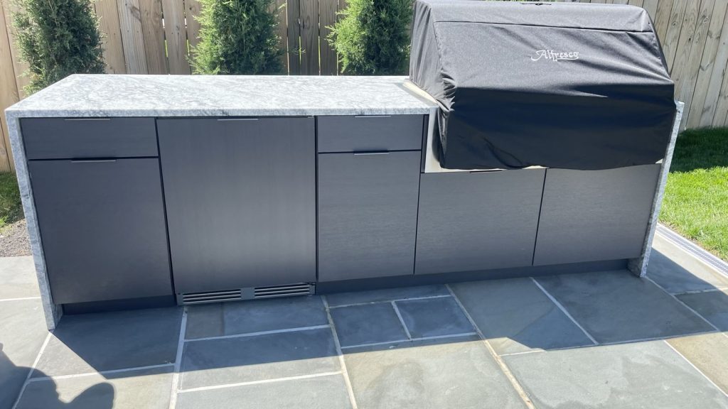 Outdoor cabinetry with waterfall-edge stone top fabricated by Exact Tops, SMFW's stone division