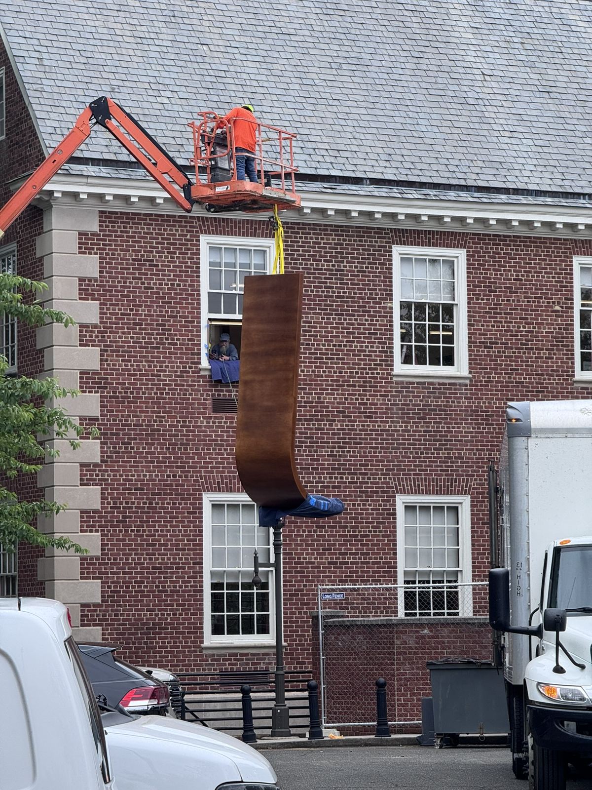 Curved bench millwork delivered by crane through a second-floor window at Petworth Neighborhood Library