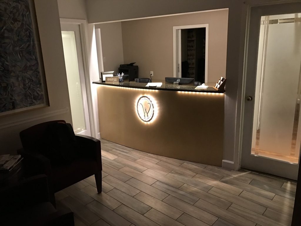 Underlit reception desk with illuminated logo at Watergate Dental