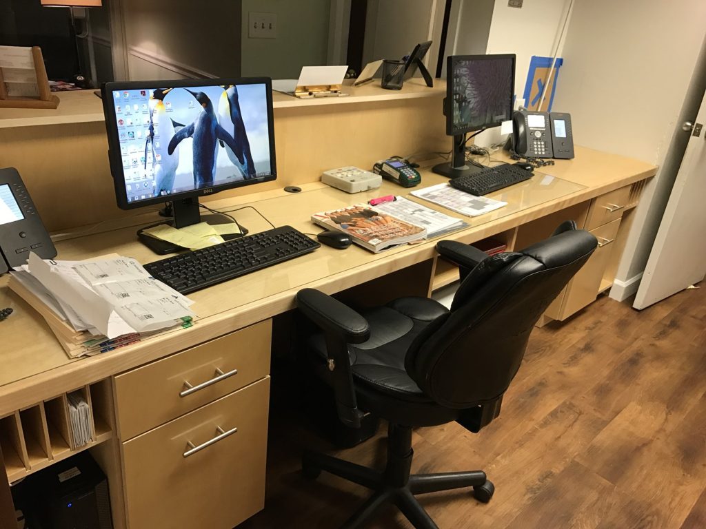 Staff-side workstation with glass-inset maple top and file storage